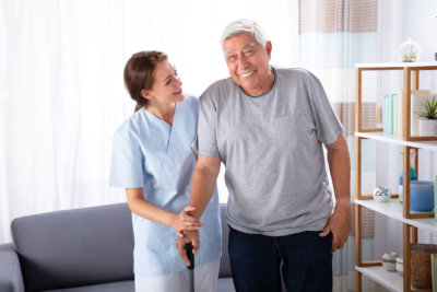 woman helping senior in walking