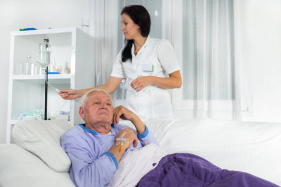 woman monitoring the IV drip of senior