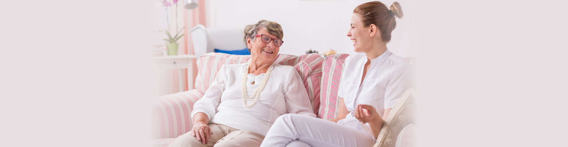 senior woman and caregiver smiling