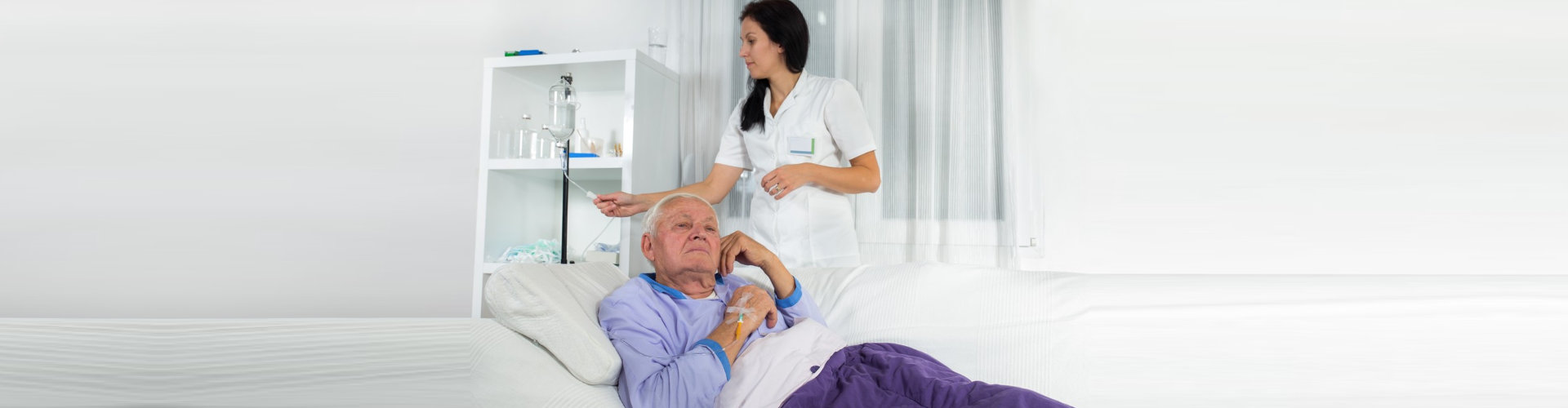 woman monitoring the IV drip of senior