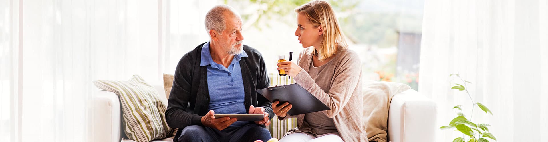 caregiver and senior man having a conversation regarding to the medicine